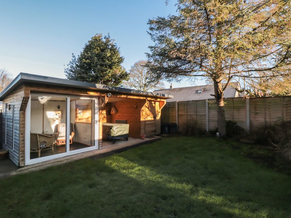 An outdoor shed with furniture and grass in the garden at 17 Costa Way Pickering