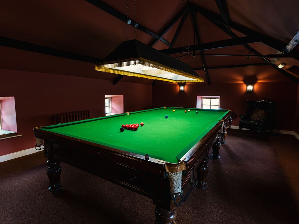 A games room with a snooker table and light fixture at Rose Cottage Akeld near Wooler
