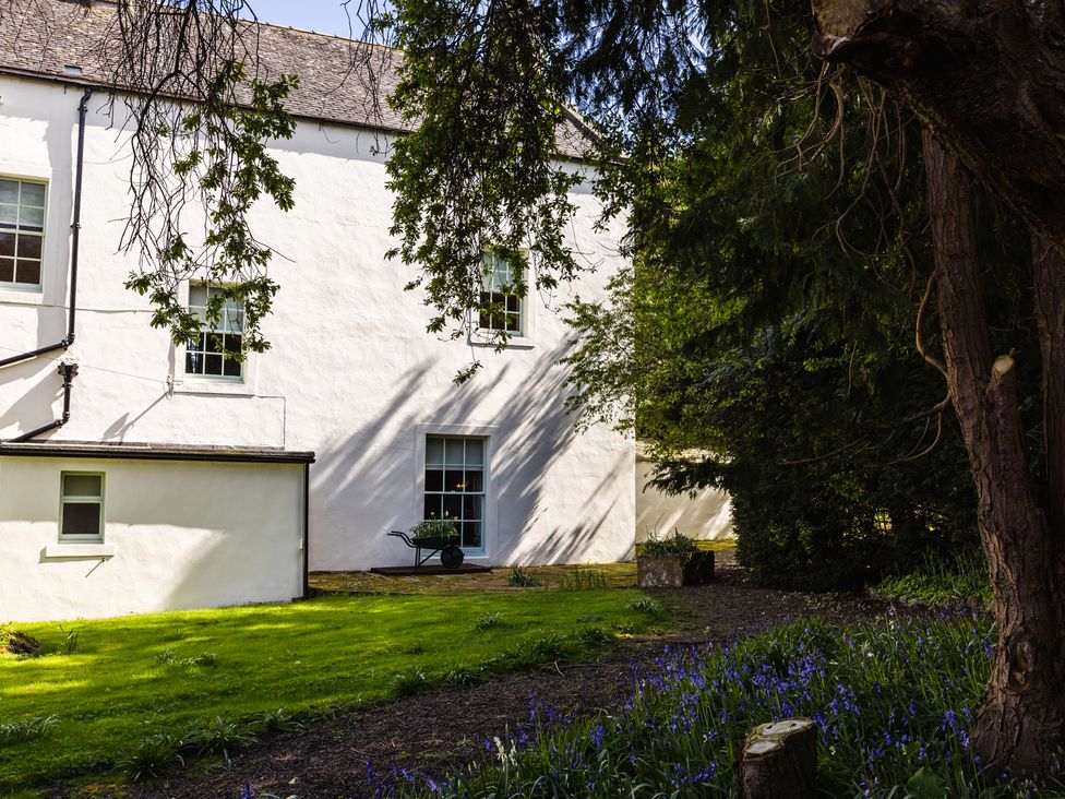 A garden with a building and trees at Rose Cottage, Akeld near Wooler