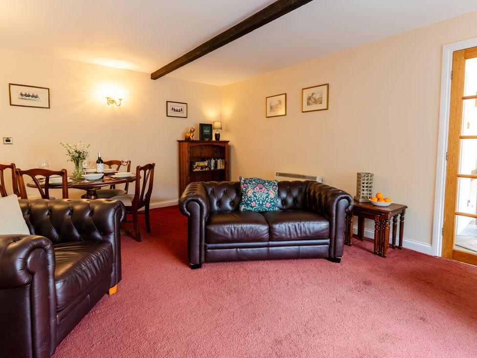 A living room with sofas and a table at Fern Cottage near Wooler