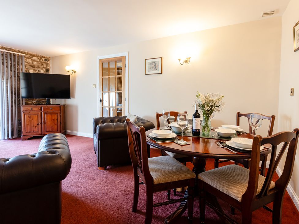 A dining room with a table and chairs at Fern Cottage in Akeld near Wooler