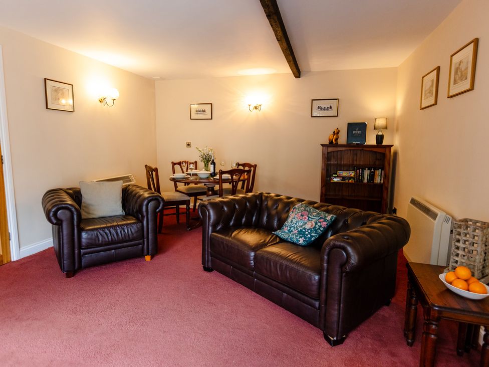 A living room with a sofa and dining table at Fern Cottage Akeld near Wooler