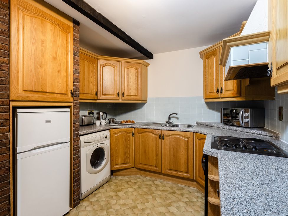 A kitchen with cabinets and appliances at Fern Cottage Akeld near Wooler