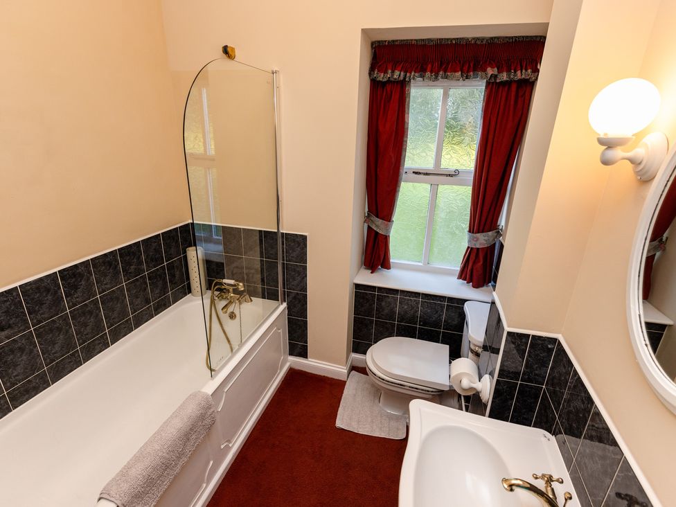 A bathroom with a bathtub, toilet, and sink at Fern Cottage Akeld near Wooler