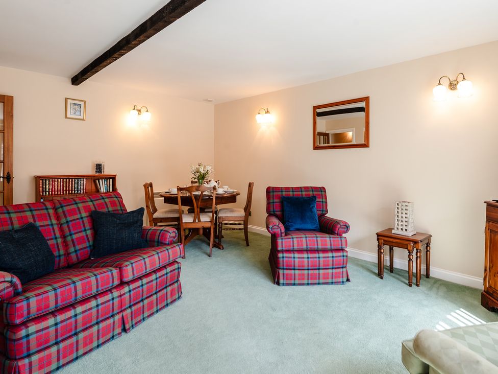 A living room with sofa and dining table at Lupin Cottage in Akeld near Wooler