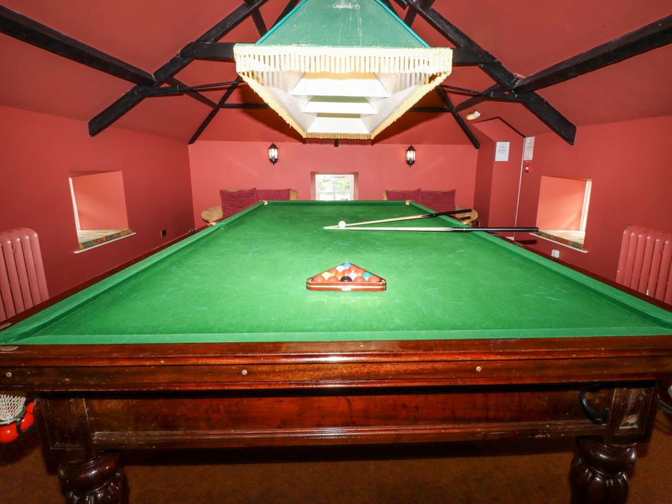 A snooker table with cue and balls in a games room at Cherryburn Cottage in Akeld near Wooler