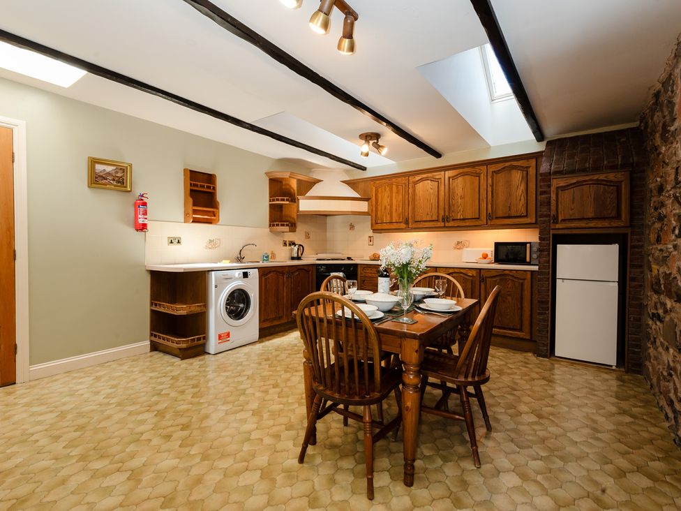 A kitchen with a dining table and washing machine at Bramble Cottage Akeld near Wooler