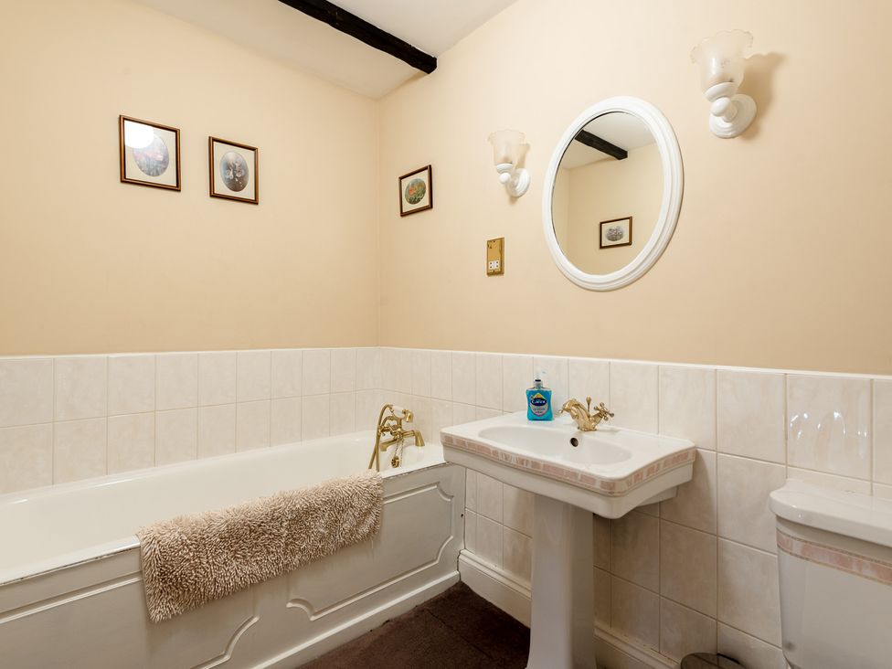 A bathroom with a bathtub and sink at Bramble Cottage in Akeld near Wooler