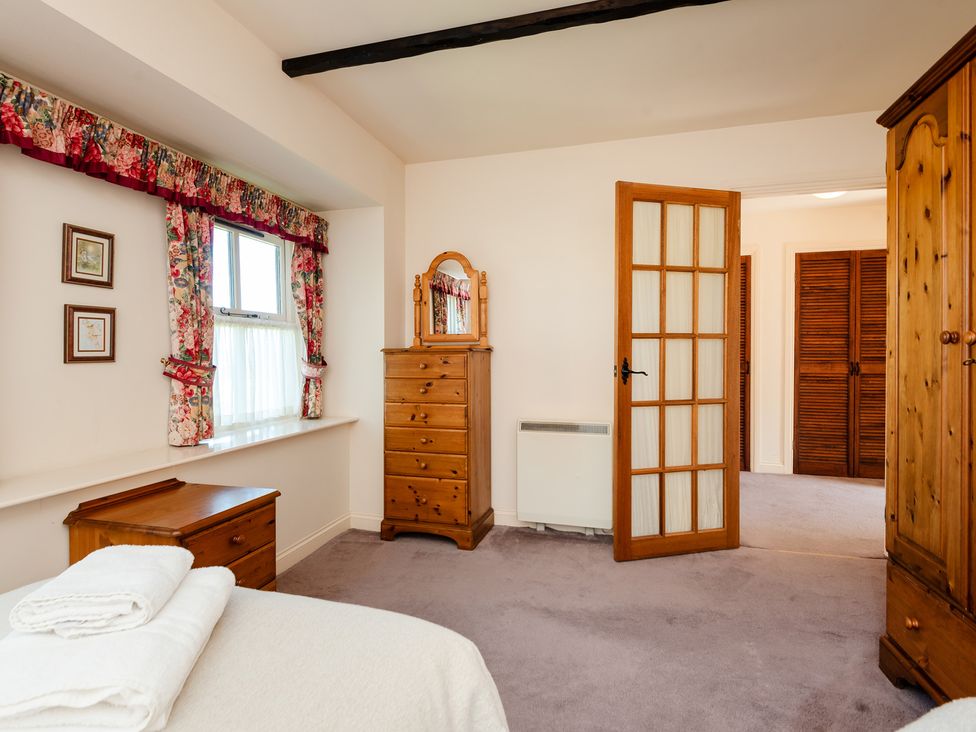 A bedroom with a bed and wardrobe at Bramble Cottage Akeld near Wooler