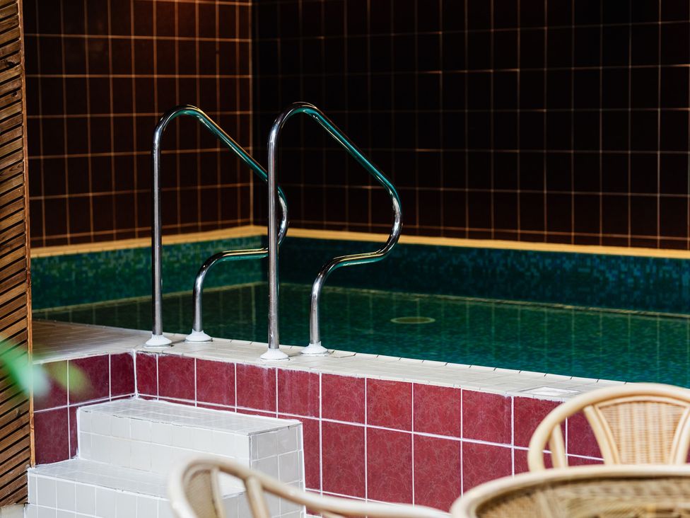 An indoor pool area with stair access and handrails at Tile Rouge Wooler