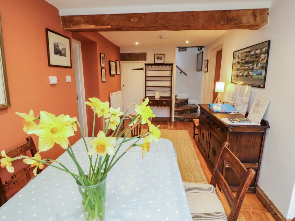 A dining room with a table and flowers at Two Town End in Mungrisdale, Mosedale