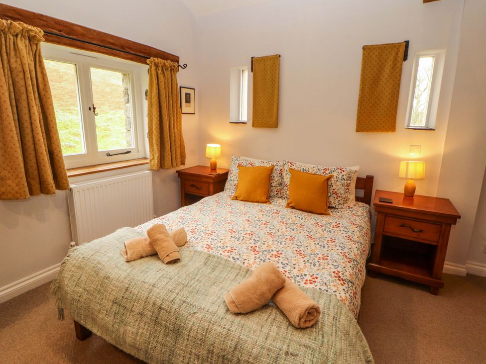 A bedroom with a double bed and nightstand at Two Town End, Mungrisdale, Mosedale