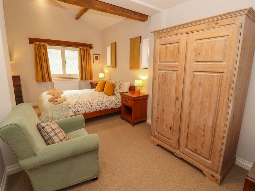 A bedroom with a bed and wardrobe at Two Town End in Mungrisdale, Mosedale