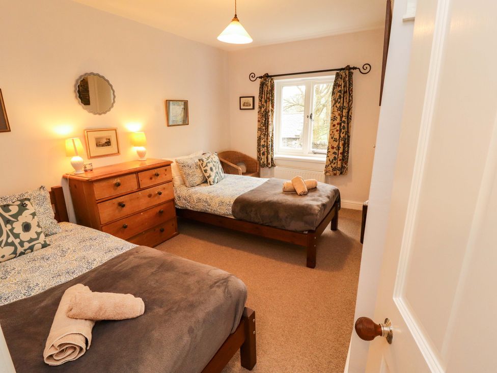 A bedroom with two beds and a dressing table at Two Town End Mungrisdale, Mosedale