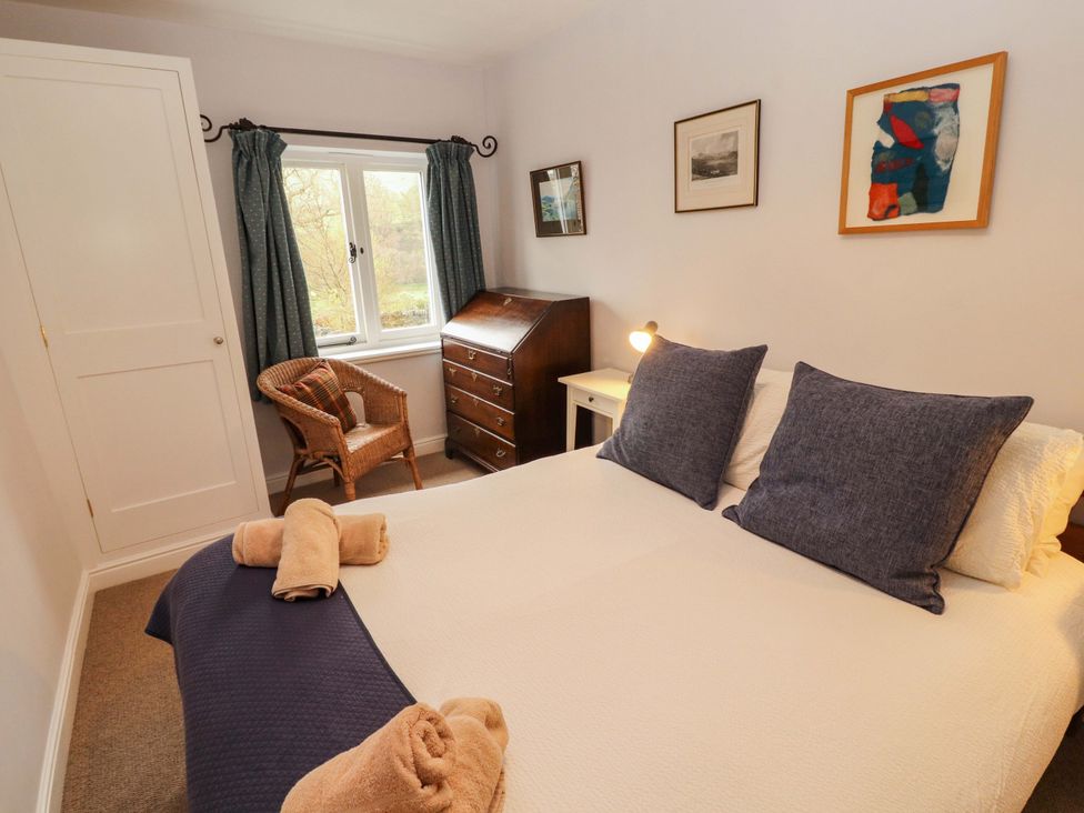 A bedroom with a bed and a chair at Two Town End in Mungrisdale, Mosedale