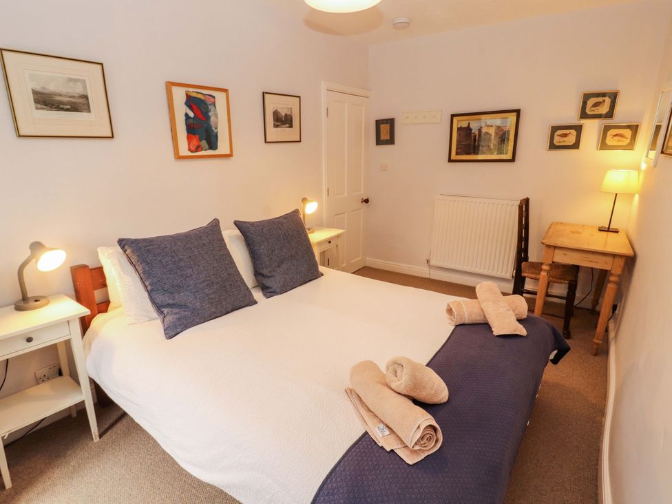A bedroom with a double bed and artwork at Two Town End in Mungrisdale, Mosedale