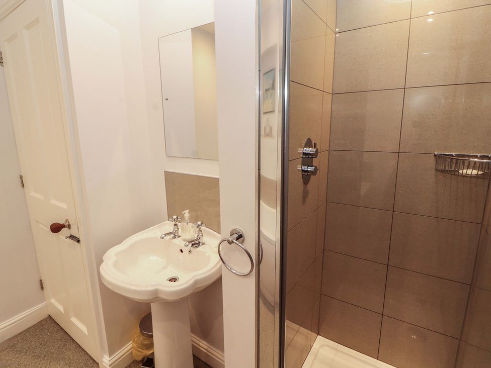 A bathroom featuring a sink, mirror, shower and toilet at Two Town End, Mungrisdale, Mosedale