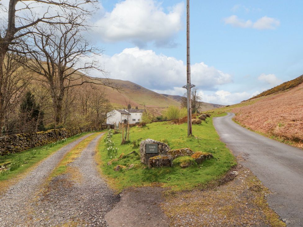 A road with a house and sign at Town End in Mungrisdale, Mosedale