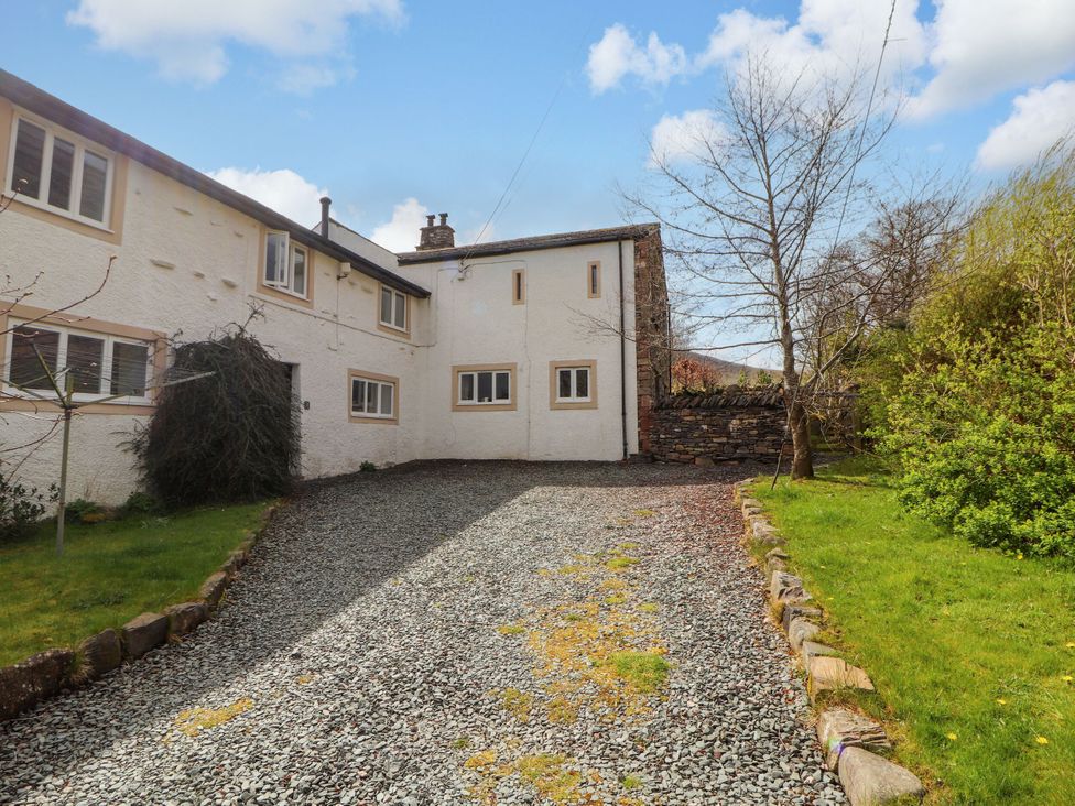 An outdoor area with a gravel driveway and trees at Two Town End in Mungrisdale, Mosedale
