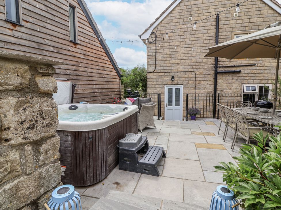 An outdoor space with a hot tub and seating area at The Stable House in Sherborne