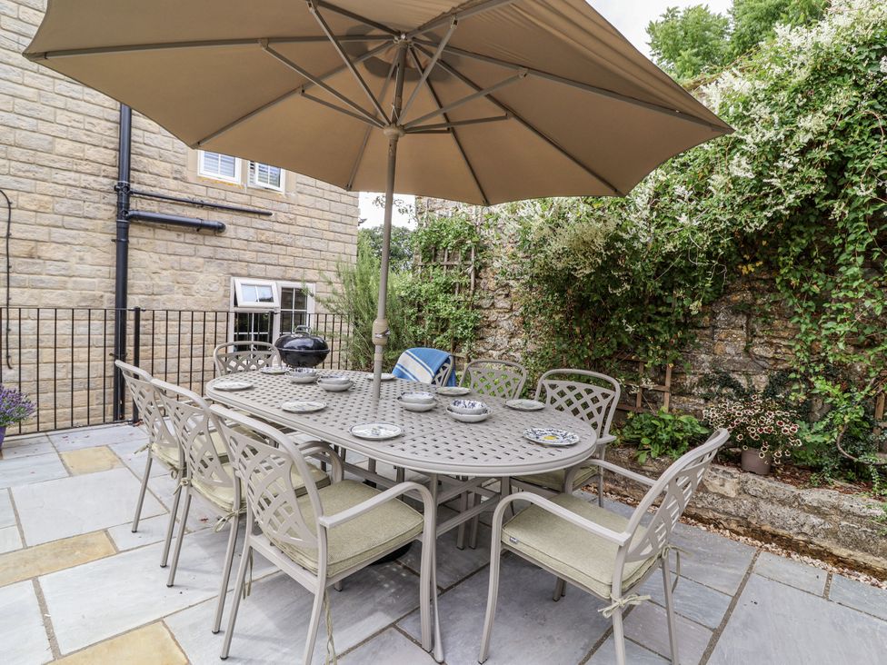 An outdoor dining area with a table and chairs at The Stable House in Sherborne
