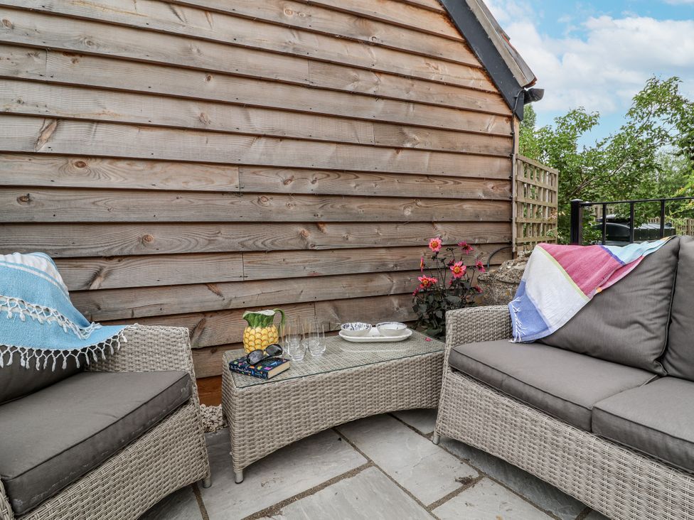 An outdoor seating area with a sofa and a table at The Stable House in Sherborne