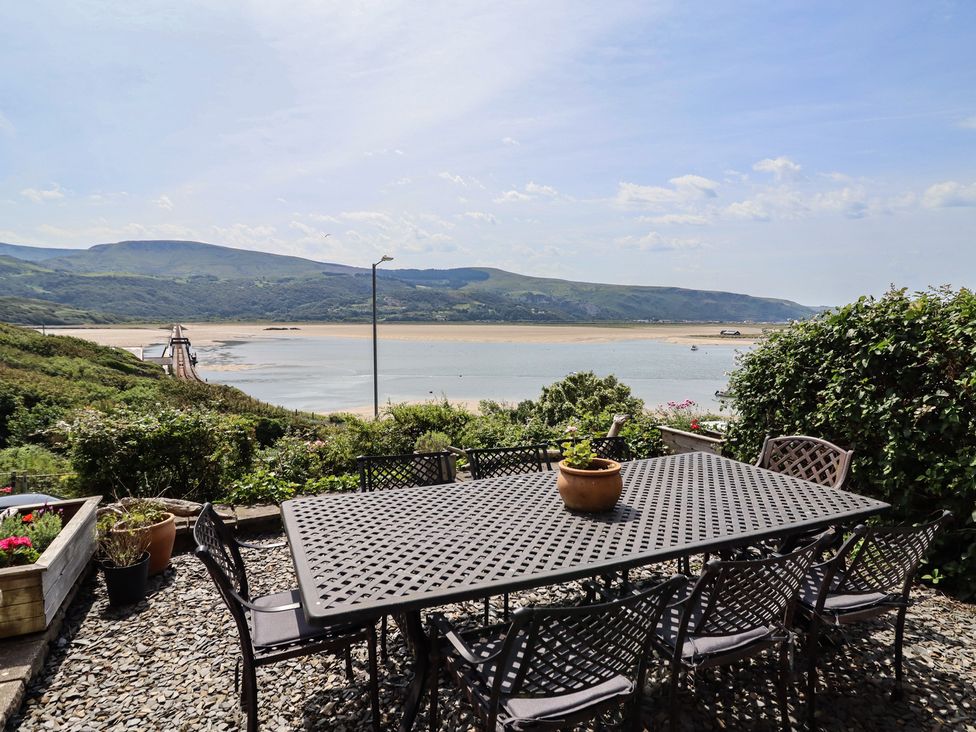An outdoor area with a table and chairs overlooking a river at 5 Porkington Terrace in Barmouth