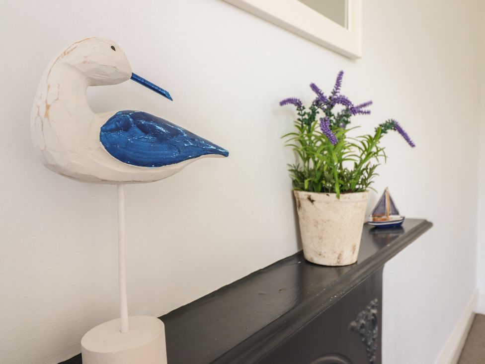 A bird decoration and plant on a mantel at 5 Porkington Terrace Barmouth