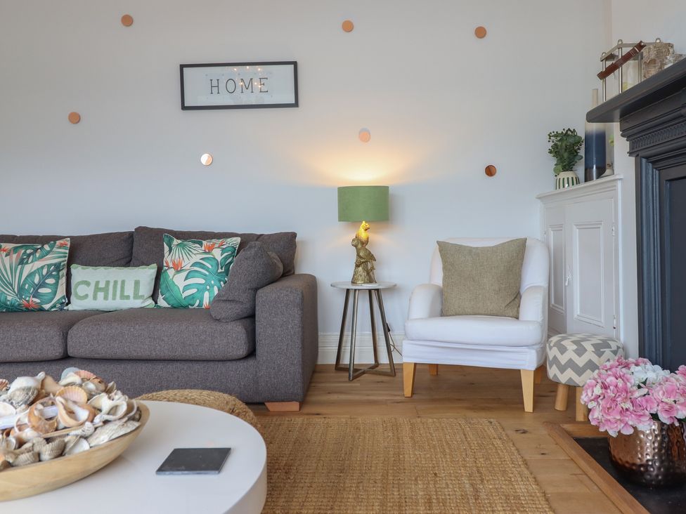 A living room with a sofa and decorative items at 5 Porkington Terrace in Barmouth