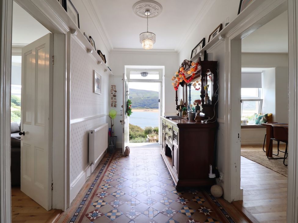 A hallway with a decorative console table and a view of the outdoors at 5 Porkington Terrace in Barmouth