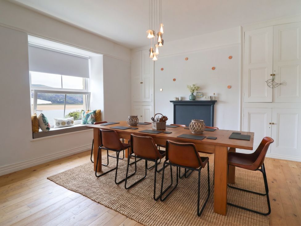 A dining room with a table and chairs at 5 Porkington Terrace Barmouth