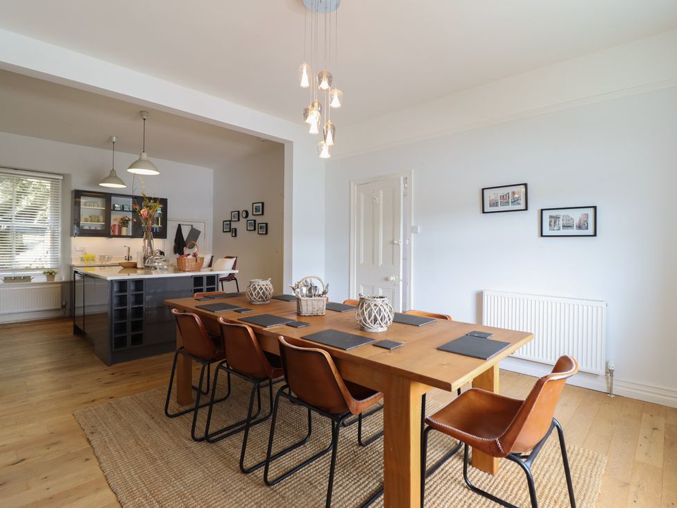 A dining room with a table and chairs at 5 Porkington Terrace in Barmouth