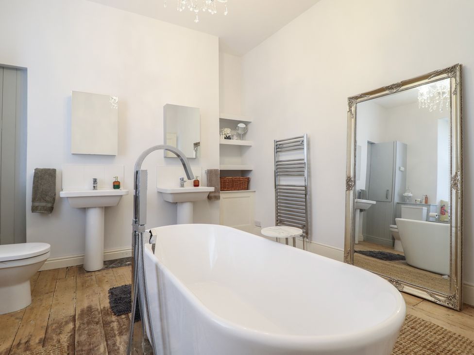 A bathroom with a bathtub and sinks at 5 Porkington Terrace in Barmouth