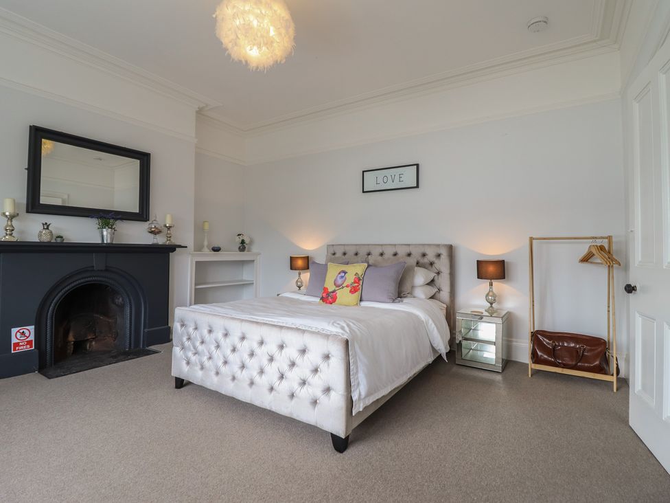 A bedroom with a bed and lamp at 5 Porkington Terrace in Barmouth