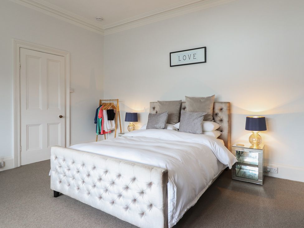 A bedroom with a bed and clothes rack at 5 Porkington Terrace in Barmouth