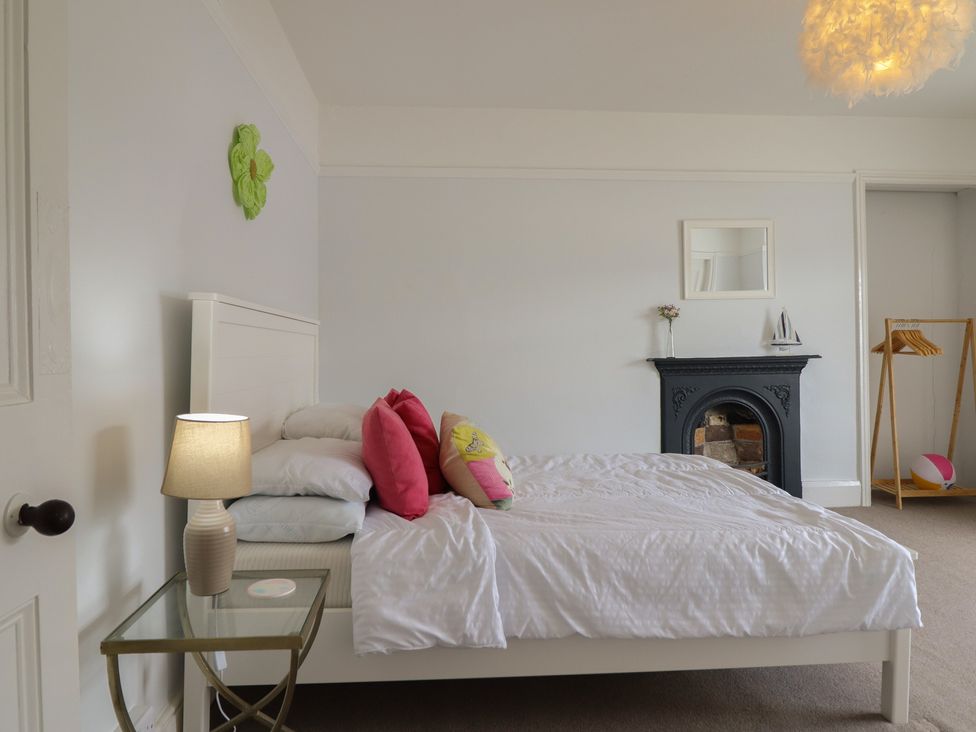 A bedroom with a bed and lamp at 5 Porkington Terrace in Barmouth