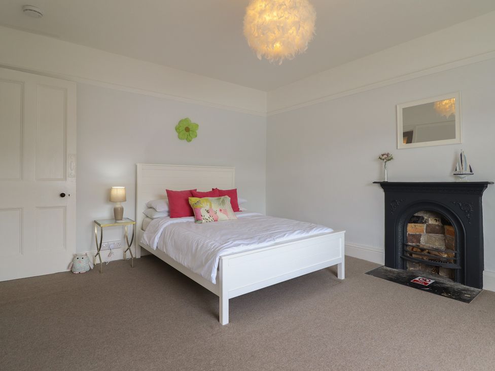 A bedroom with a bed and lamp at 5 Porkington Terrace in Barmouth