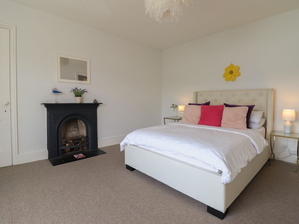 A bedroom with a bed and bedside tables at 5 Porkington Terrace in Barmouth