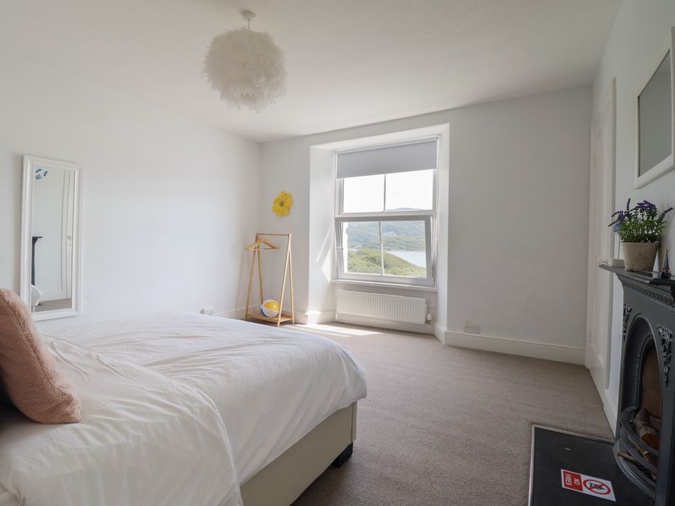A bedroom with a bed and a window at 5 Porkington Terrace Barmouth