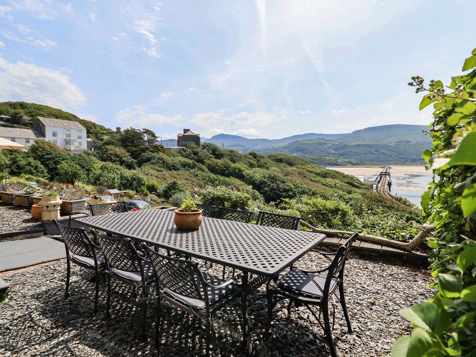 A garden with a table and chairs overlooking the sea at 5 Porkington Terrace Barmouth