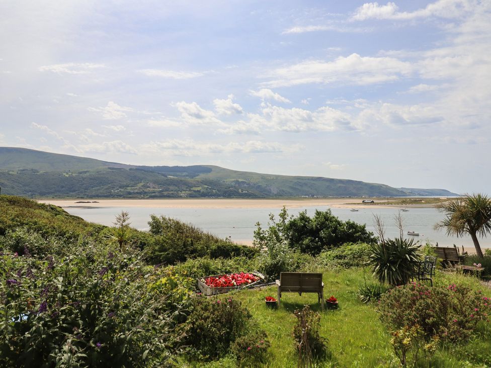 A garden with flowers and a view of the water at 5 Porkington Terrace in Barmouth