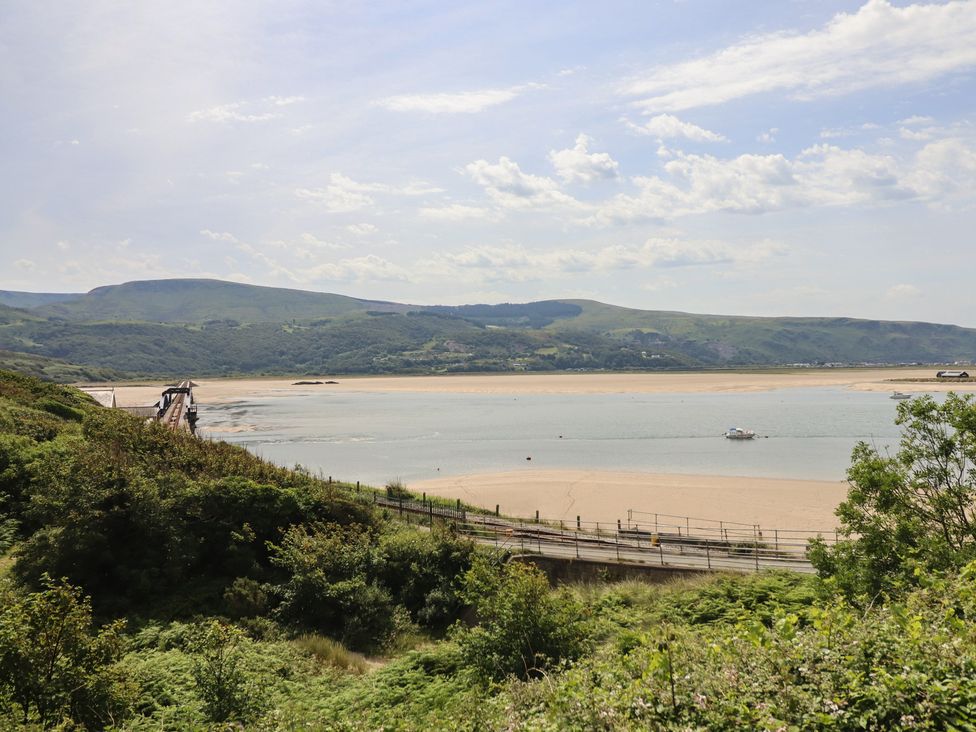 A river with sand and a bridge near mountains at 5 Porkington Terrace Barmouth