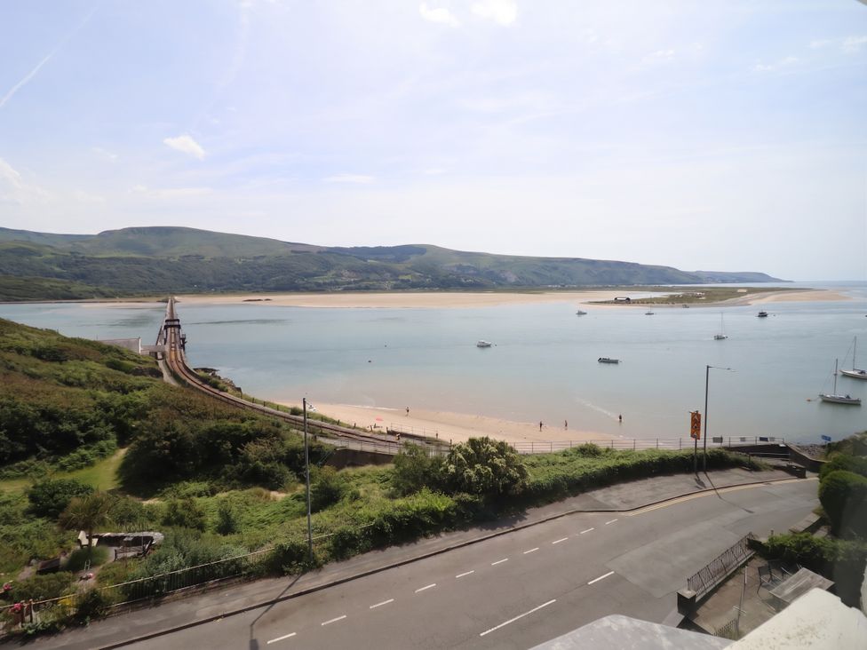 A view of a bridge over water with boats and beach at 5 Porkington Terrace in Barmouth