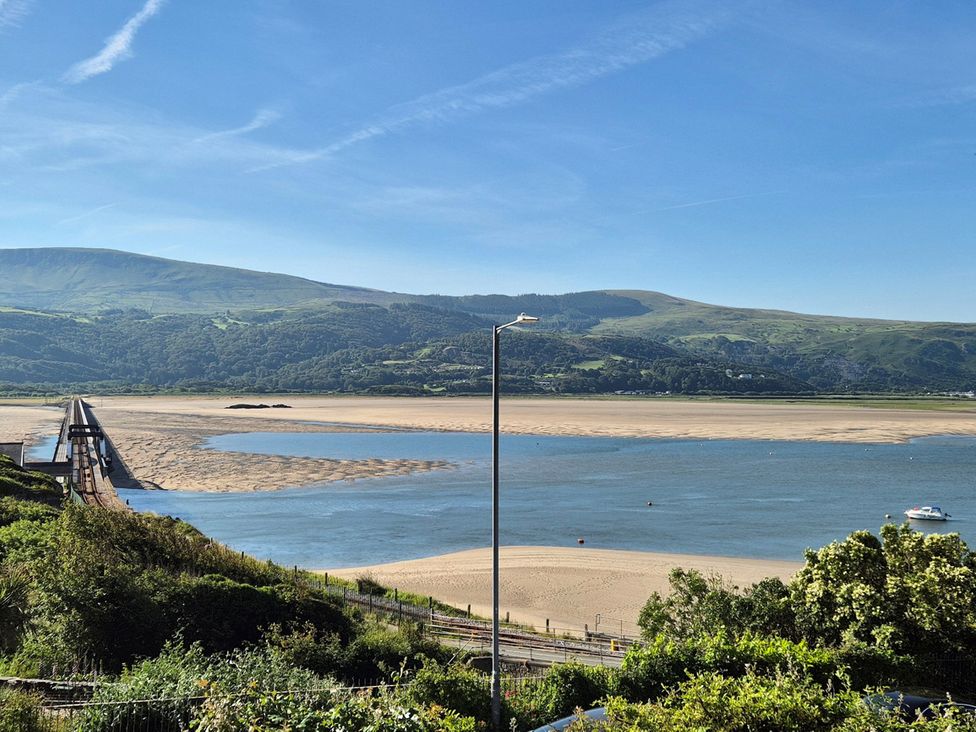 A view of mountains and beach with a bridge at 5 Porkington Terrace Barmouth