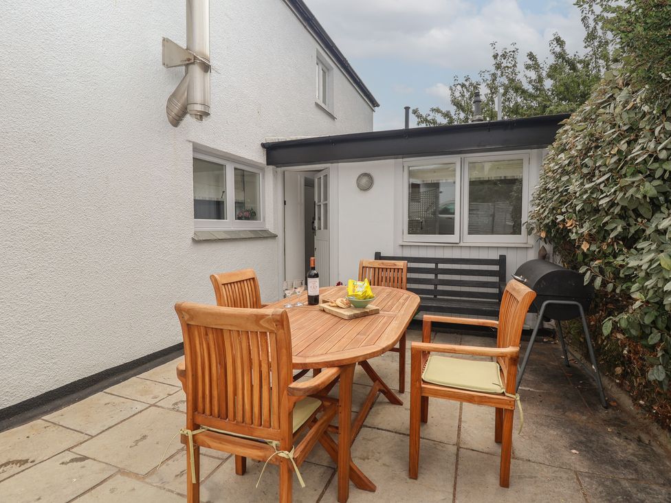 An outdoor area with a dining table and chairs at Wrens Nest in Slapton