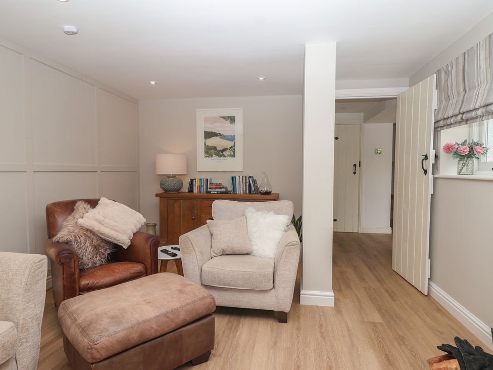 A living room with an armchair and a sofa at Wrens Nest in Slapton