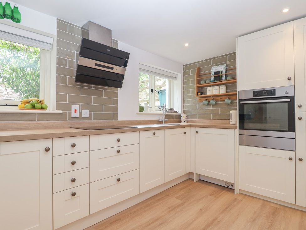 A kitchen with cabinets and appliances at Wrens Nest in Slapton