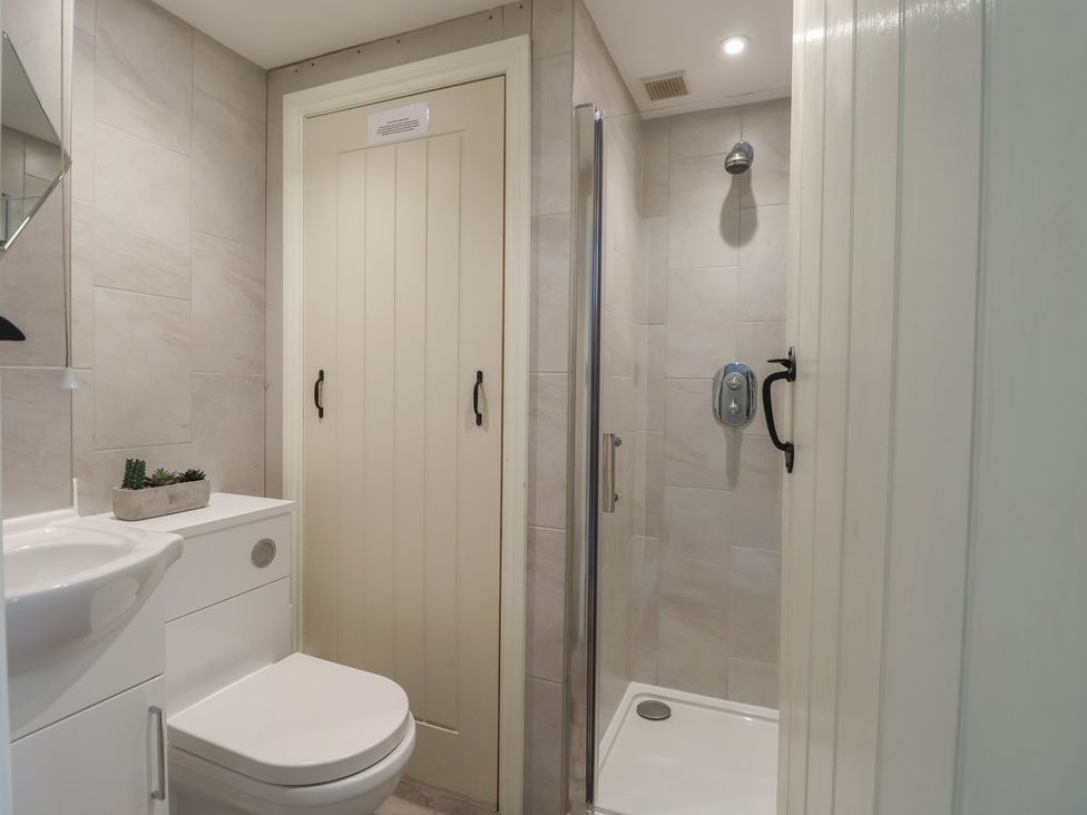 A bathroom with a shower and sink at Wrens Nest in Slapton