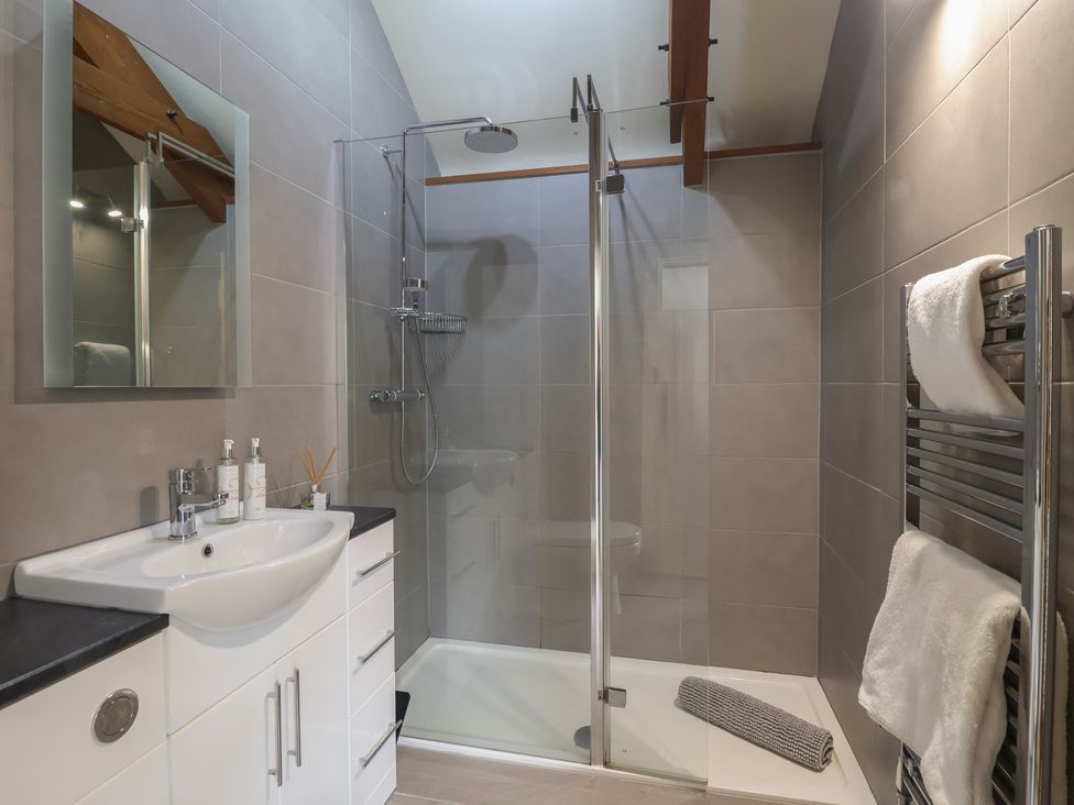 A bathroom with a shower and sink at Wrens Nest in Slapton
