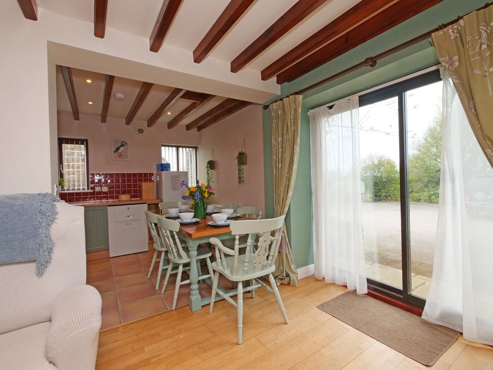 A dining area with a table and chairs at Scoresby Cottage @ Summerfield Farm in Hawsker